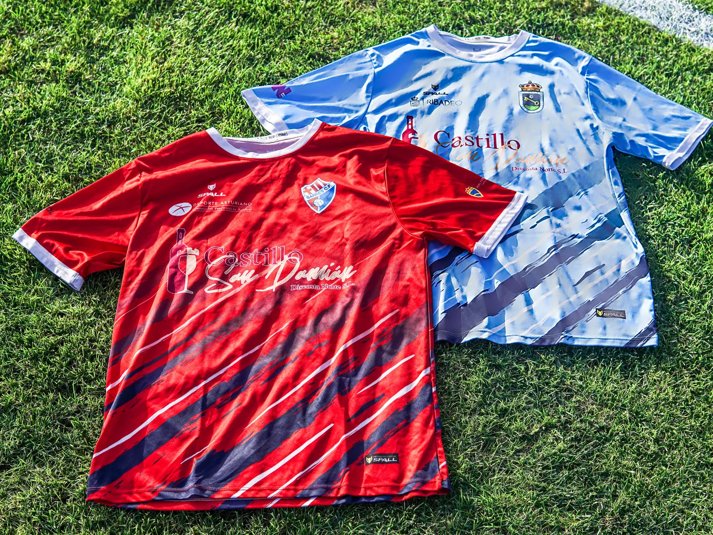 Camisetas roja del Barres C.F. y celeste de la SD Ribadeo sobre el césped